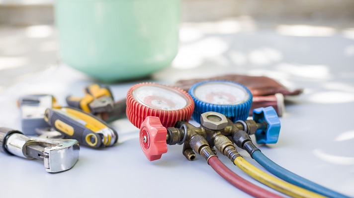 A collection of HVAC tools and supplies, including hex keys and pressure gauges